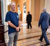 Jon Stewart smirking at McConnell after winning 9/11 benefits